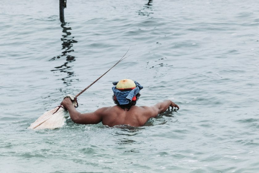 Stilt Fisherman Swimming to Stilt Pole