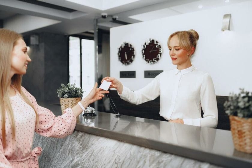 Hotel guest receiving key card from front desk staff