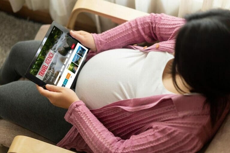 Pregnant woman searching online travel agency website